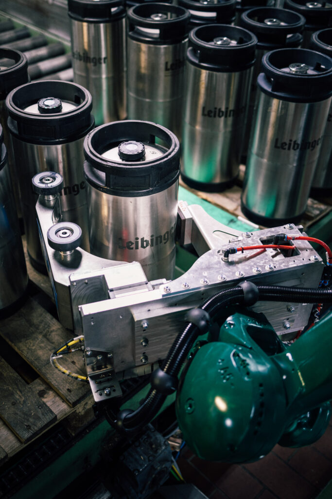 A gripper from fpt robotics picks up beer kegs and places them in the designated position.
